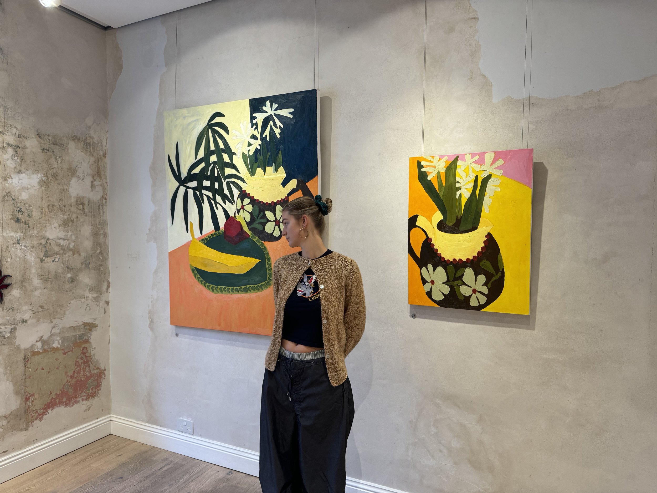 Nina Parsons with her artwork displayed in a gallery